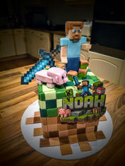 minecraft building block effect cake with a figure of a minecraft pig and minecraft man
