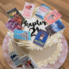 Buttercream finished cake with chapter 21 writing and lots of different edible books