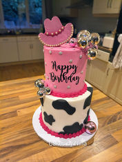 A bright pink layer, cow girl theme cake with glitter disco balls