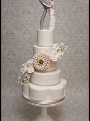 Contemporary handcrafted bride and groom wedding cake figures with elongated sculptural design, detailed wedding dress and modern suit by Cakes by Nina