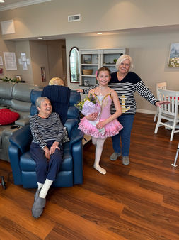 Residents and a young ballet dancer sharing a joyful moment in the cozy living room at Evergreen Gardens Assisted Living and senior care home in Strongsville, Ohio, highlighting intergenerational connection and community engagement.