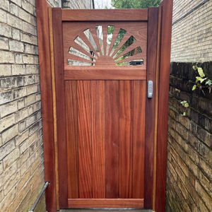 The Sunshine Gate In Sapele Installed With Timber Wall Plates Between Two House Walls Front View