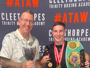 Graham Cowan of Graham Cowan QHSE Consultancy Services with a representative from Cleethorpes Trinity Boxing Academy, holding a championship belt at The Trin Centre.