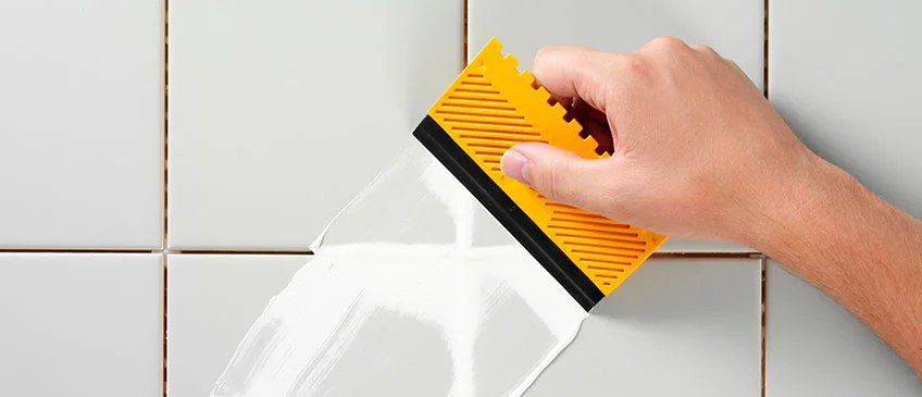 Picture of someones hand grouting a wall