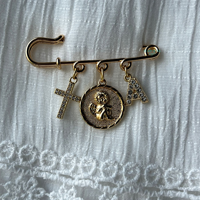 Catholic pin with angel charm symbolizing protection and guidance