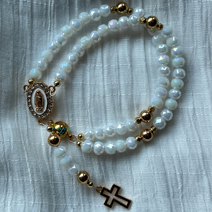 Iridescent white rosary bracelet with gold-plated Virgin Mary medallion and cross charm.