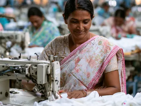 A garment worker sewing in a factory, illustrating living wage and ethical supply chain questions in childrenswear.