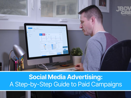 A man at a desk works on a computer displaying analytics. Text overlay reads "Social Media Advertising: A Step-by-Step Guide to Paid Campaigns."