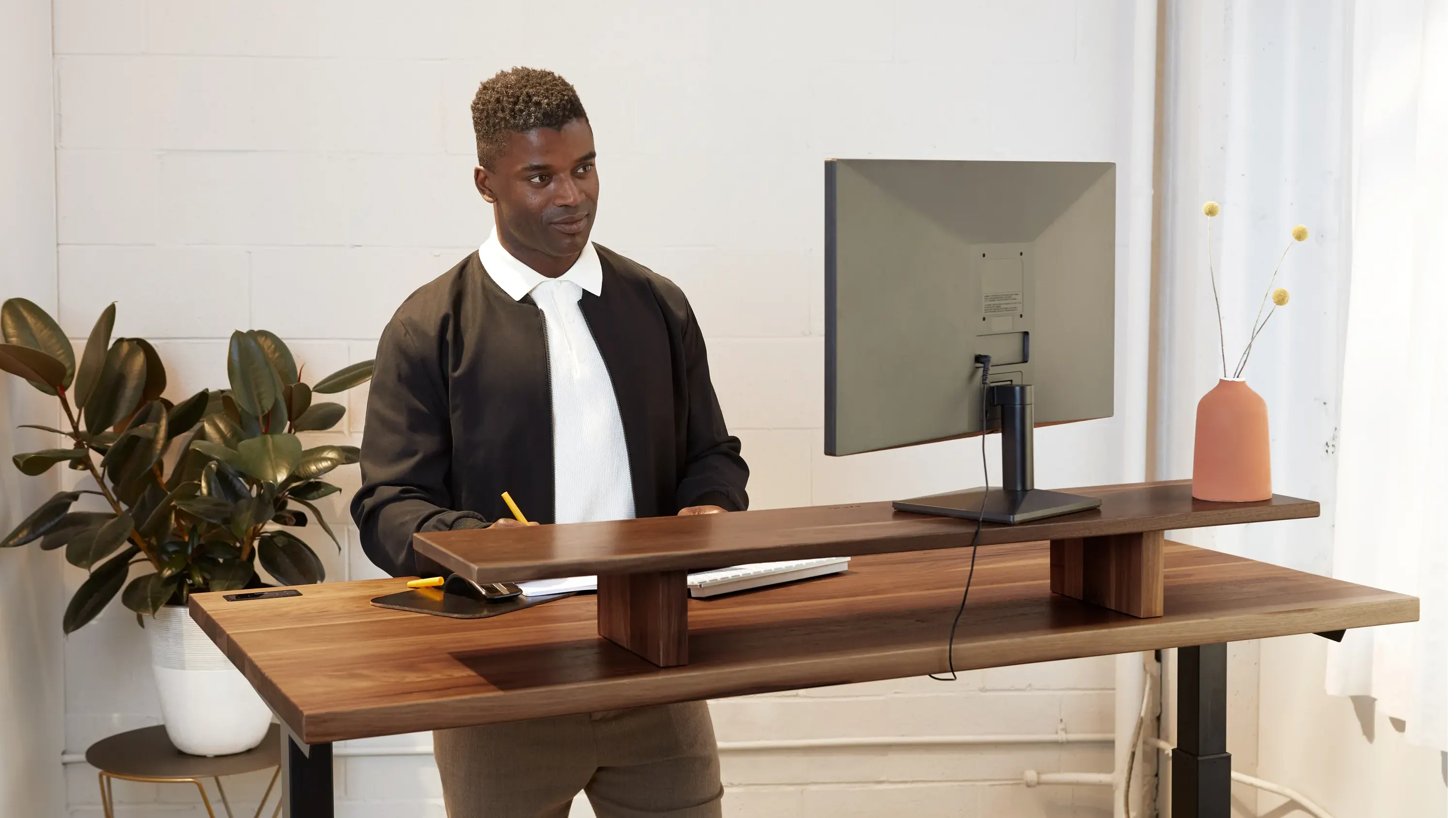 A man working in front of his desk while standing