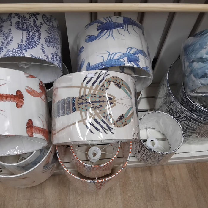 Selection of lampshades with seaside designs such at lobsters and seaweed.