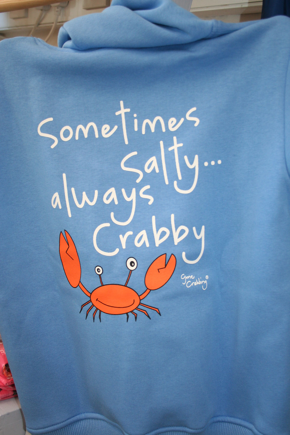 Blue fabric printed with the words Sometimes salty...always Crabby-Gone Crabbing and a cheerful orange crab waving it's pincers