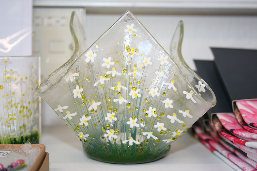 handmade glass candle holder decorated with tiny white flowers with yellow centres and thin strands of green grass