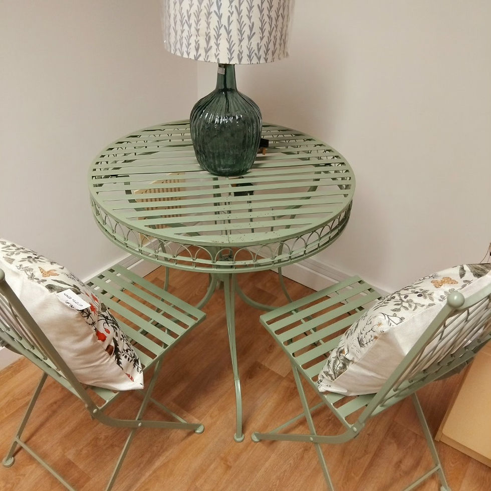 green slatted metal bistro table an chairs with lamp and scatter cushions linked to the homewares section of the website