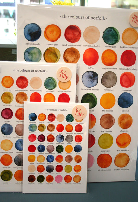 white greetings cards and wall prints printed with different coloured paint samples representing Norfolk with descriptive words below each sample and By Tilly branding
