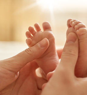 mum-making-baby-massage-mother-massaging-infant-bare-foot-preventive-massage-newborn-mommy
