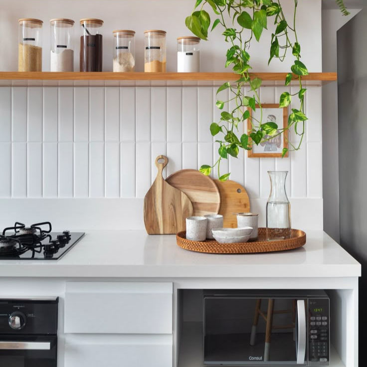 Cozinha branca com utensílios em madeira e decoração boho chique