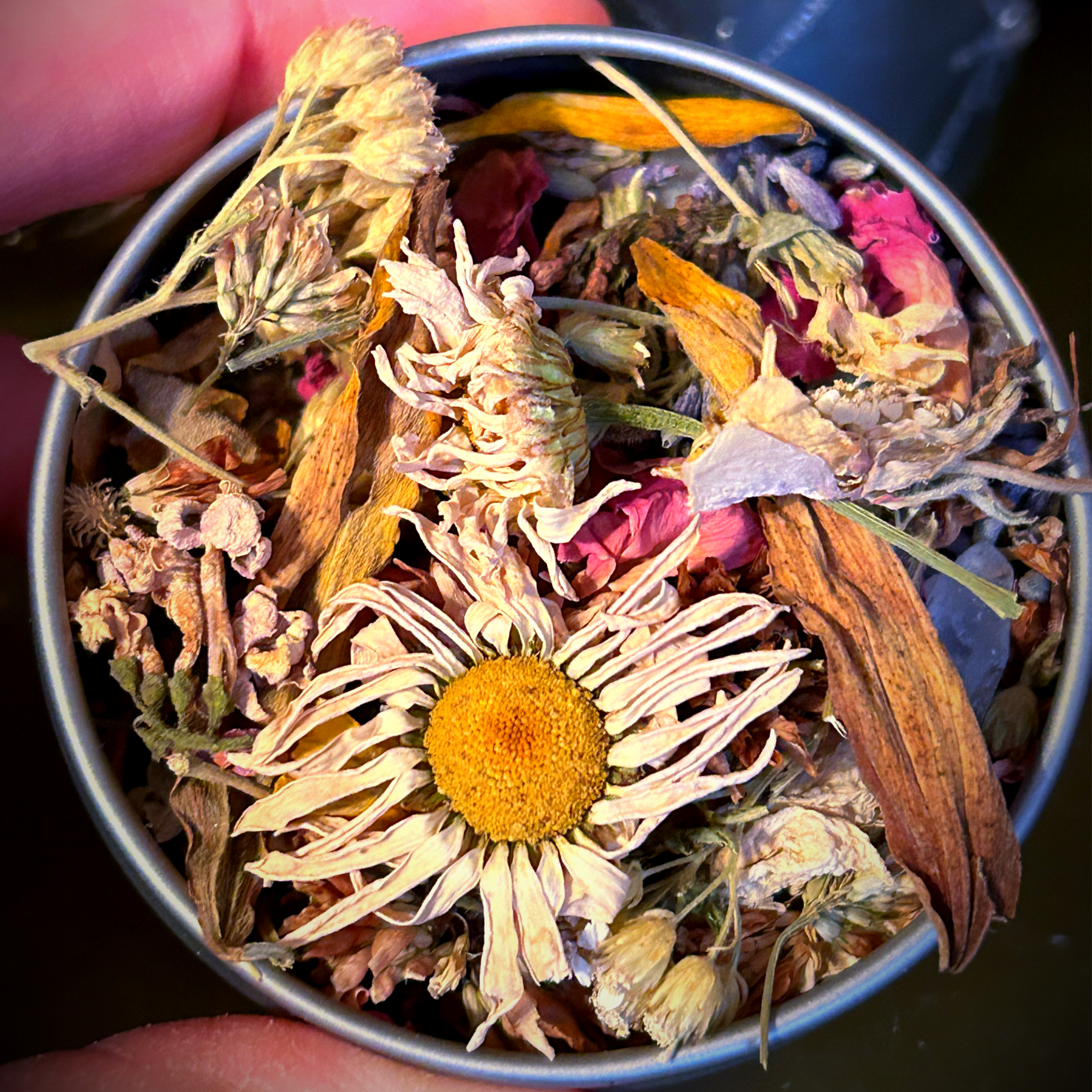 Witchcraft offering tin filled with herbs flowers and natural crystals