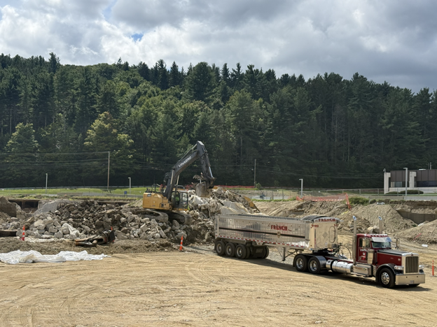 Dump trailers remove the Regulator House 3 demolition debris from the site. These trailers can haul about 30 tons per load. About 10-15 trucks visited the site daily for cleanup.