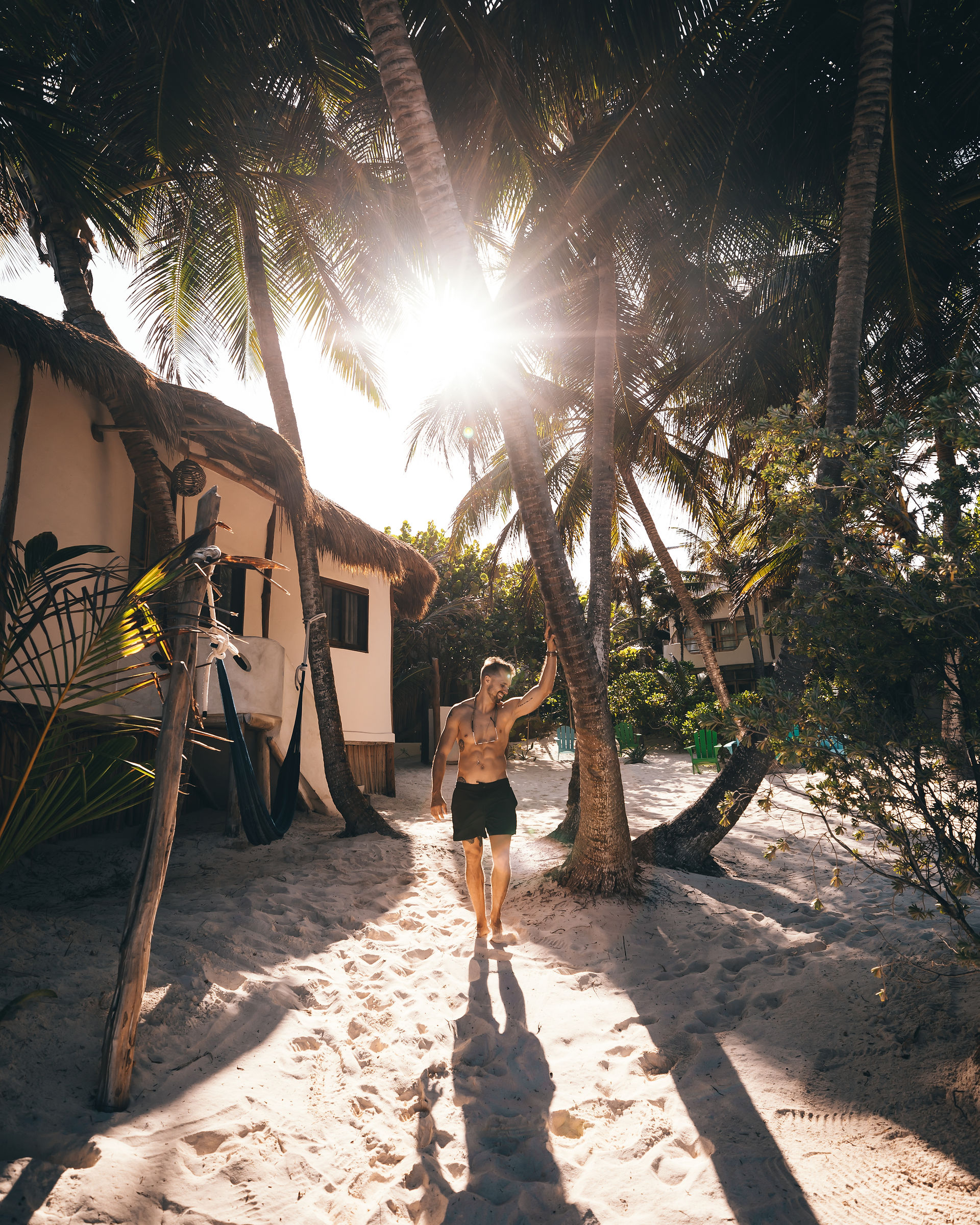 Man relaxing on the beach by palm tree in Tulum, Mexico