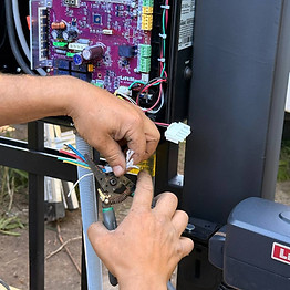 Asgard Gates specialist cuts and connects wires to automation control box