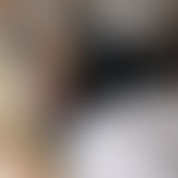 A high-angle shot of a therapist's hands performing a physical assessment or manipulation on the hip and pelvic area of a patient wearing black leggings and a white t-shirt, lying supine on a treatment table.