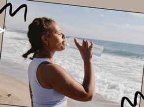 Woman in white sports bra and shorts sitting on yoga mat.