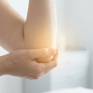 A person holding their elbow with a glowing yellow highlight indicating joint pain, representing conditions like tennis elbow.