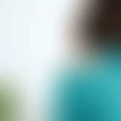 Close-up of a practitioner applying shockwave therapy to a patient’s lower back using a handheld device, with gel on the skin and a towel draped over the patient.