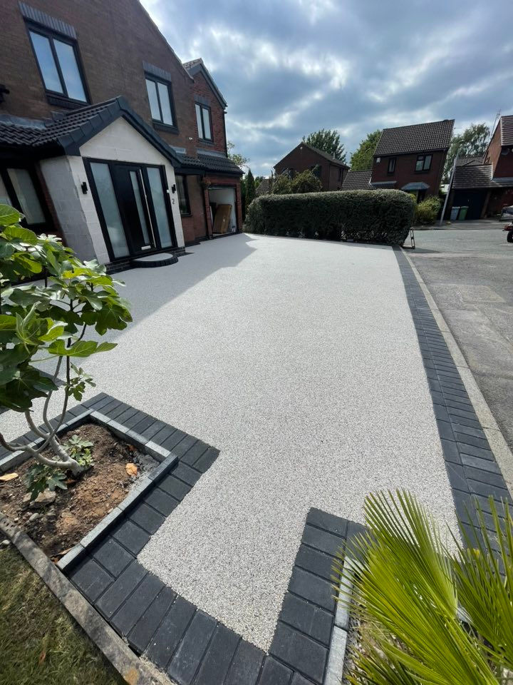 rey resin driveway with black block paving border at a residential property in Plymouth