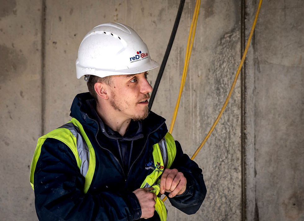 Candid, natural environmental portrait of an engineer in high-vis and hard hat.