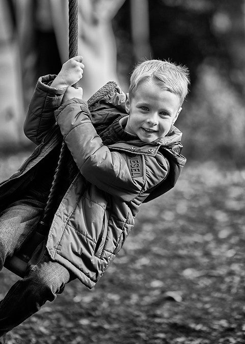 Black and white portrait photography of young boy on zip wire_