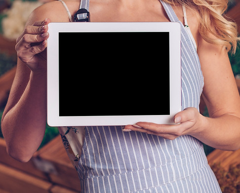 portrait-smiling-blonde-young-female-florist-showing-digital-tablet-with-black-screen-disp