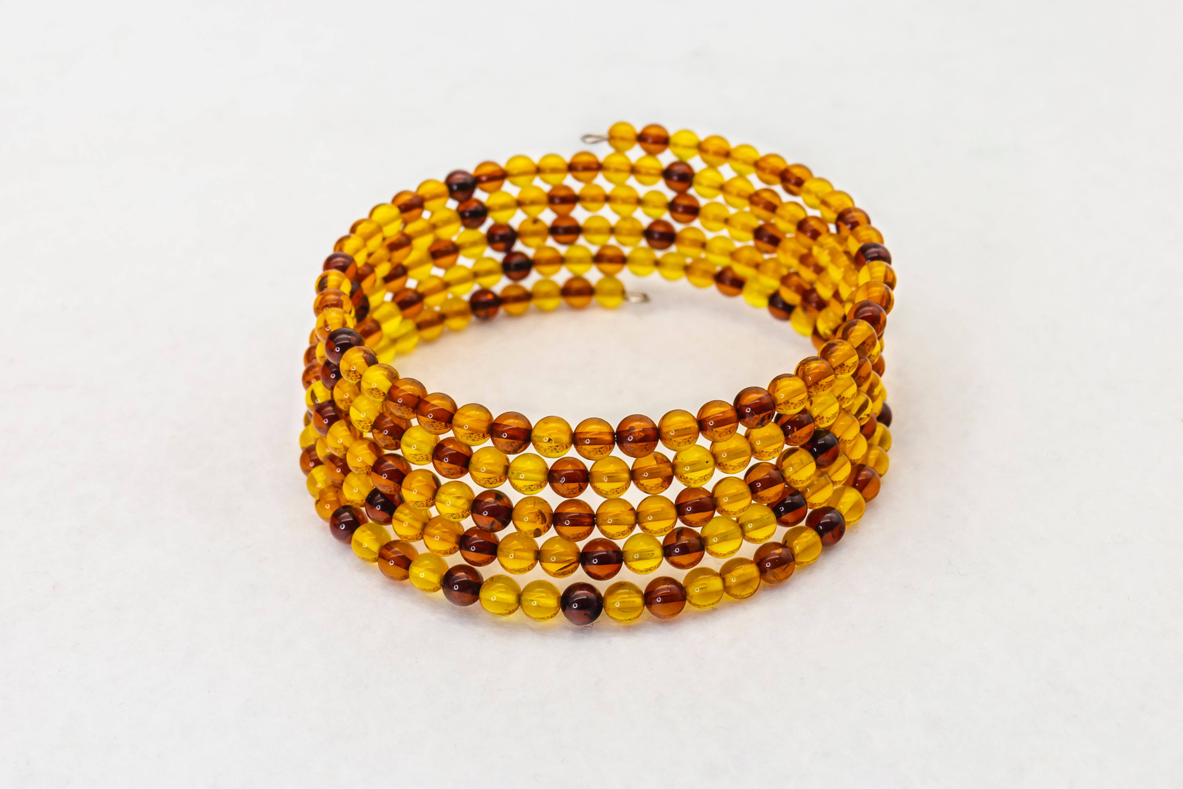 Bracciale a cinque giri di acciaio armonico con sfere di ambra baltica multicolore