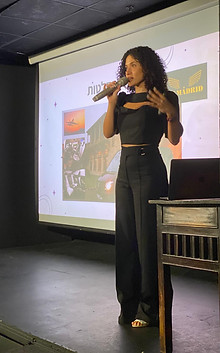 רעות תות עומדת על במה ומרצה לארגון