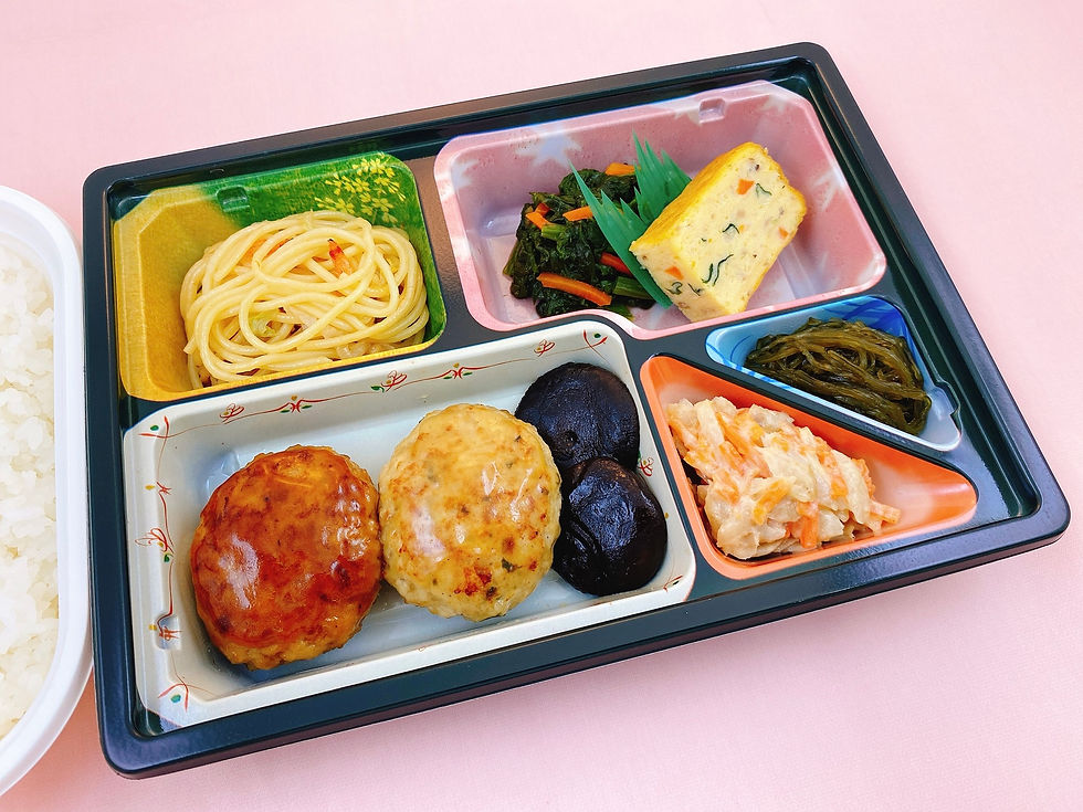 4月の行事食は4月26日(火)の夕食です。「名古屋コーチン鶏つくね弁当」をご用意いたしました。 三大地鶏の一つと呼ばれている名古屋コーチンを使用して鶏つくねを作りました。 旨味が凝縮した名古屋コーチンに豆腐や卵を加えてやわらかい食感のつくねに仕上げました。 醤油ベースのタレと合わせたつくねと塩ダレでさっぱりと食べられる大葉入りつくねの2種類の盛合わせです。