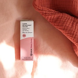 Photo d'ambiance du savon détachant Blanc Cerise x Maïa, sur du linge en lin et en gaze de coton