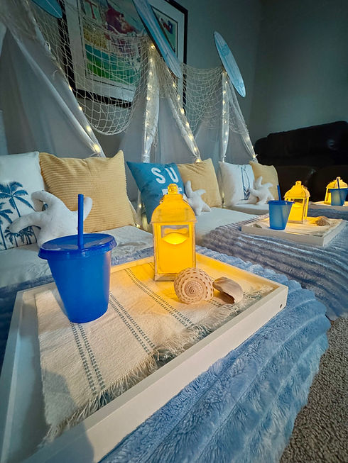 Beach themed sleepover tent with blue blanket and surf inspired pillows