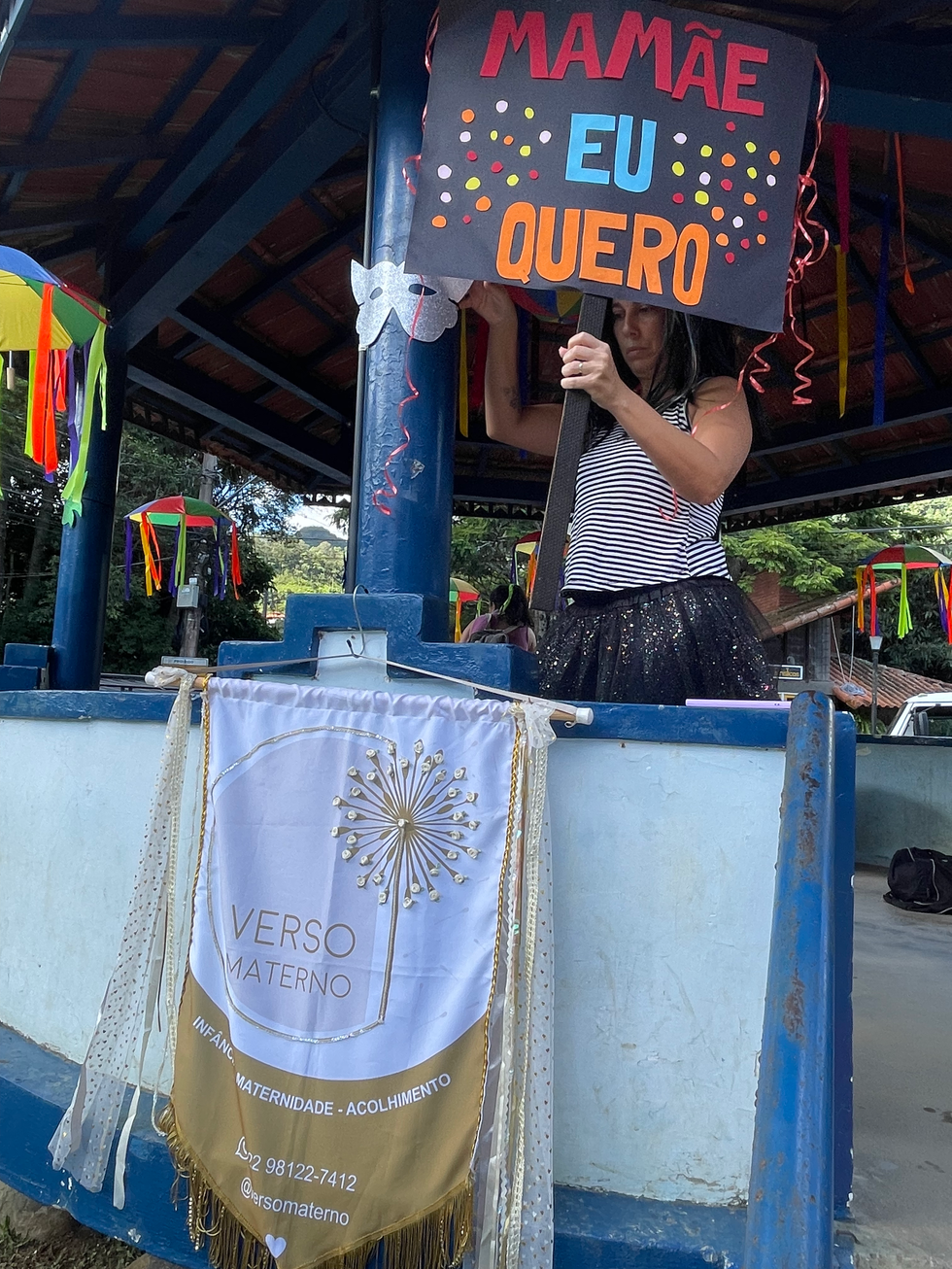 Mulher segurando cartaz EU QUERO em festa, banner VERSO MATERNO