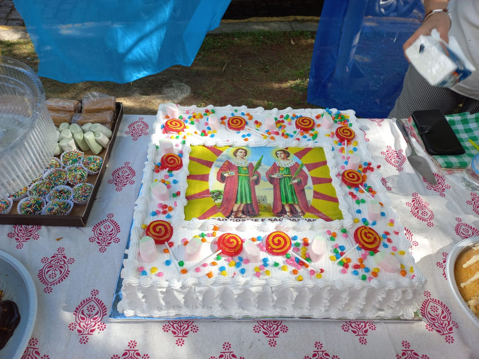 Bolo branco decorado com imagem de São Cosme e Damião.