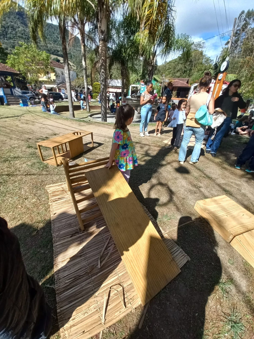Criança em festa ao ar livre com mesas de madeira.