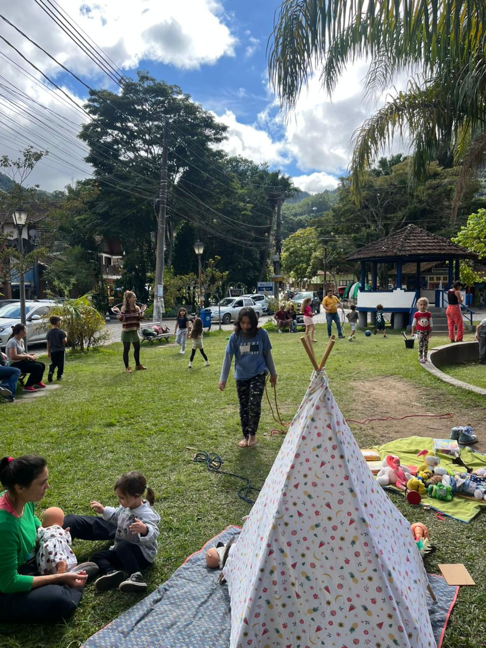 Festa das crianças ao ar livre com tenda e brincadeiras.