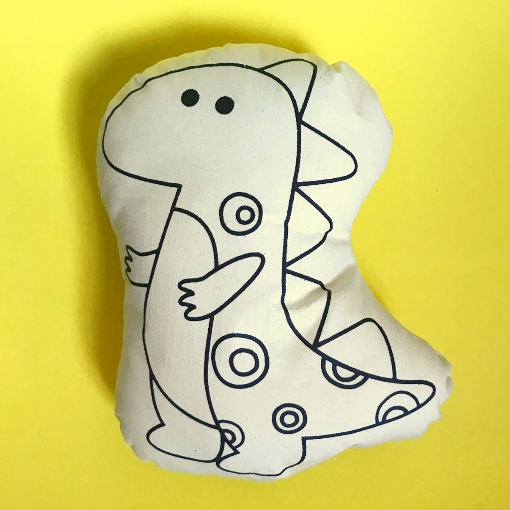 Almofadinha em tecido com ilustração de um dino para colorir.