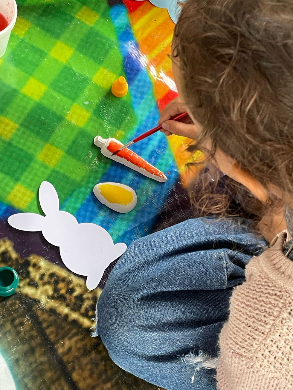Criança pintando coelho e cenoura de Páscoa