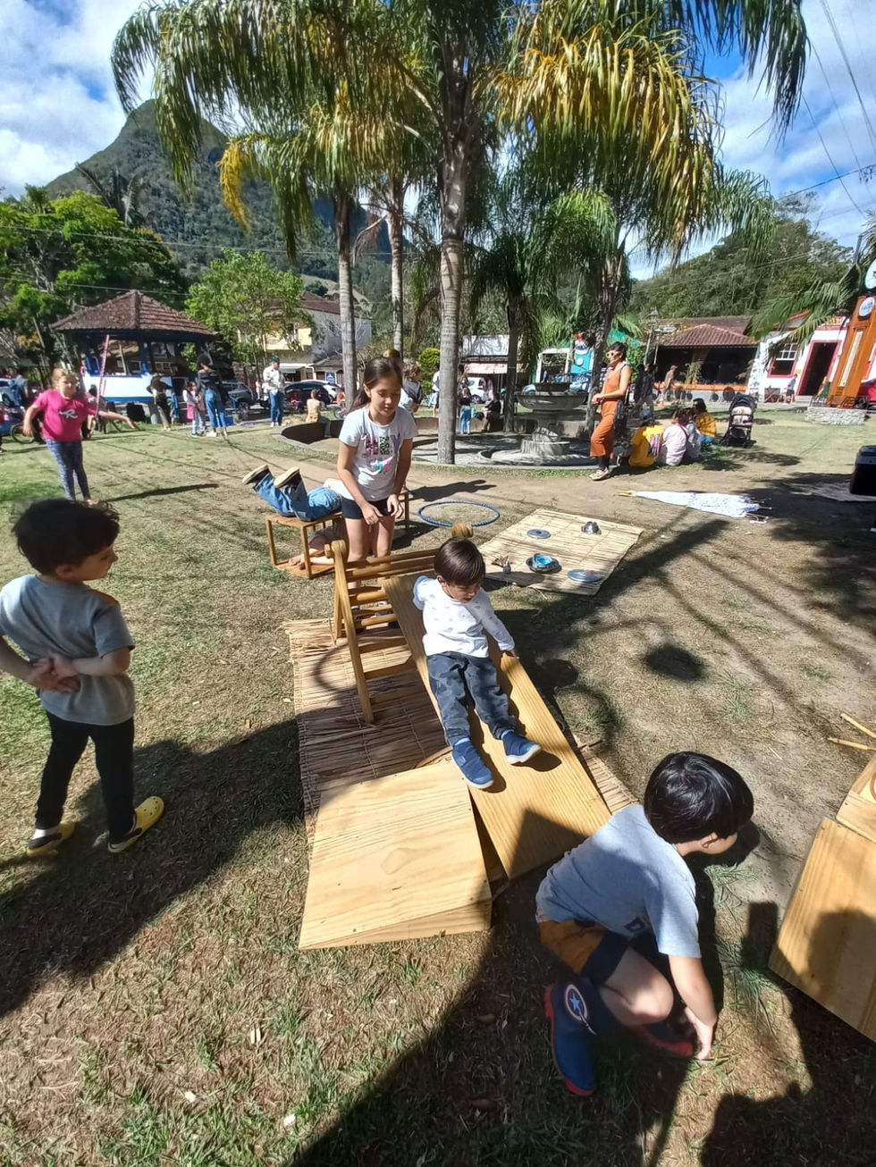 Crianças brincando com brinquedos de madeira na festa.