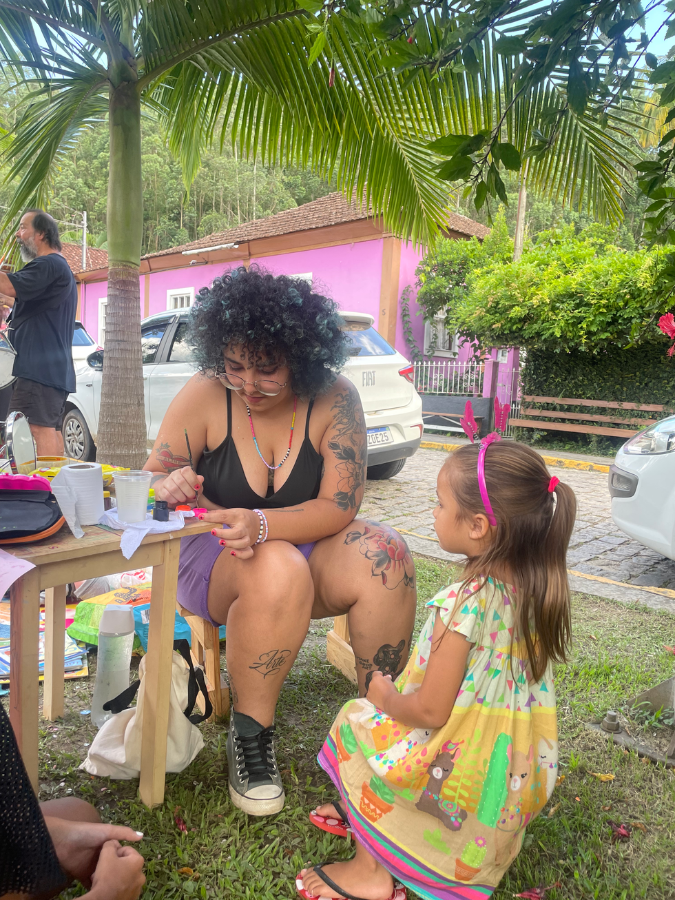 Mulher e menina em atividade de pintura na Festa das Crianças