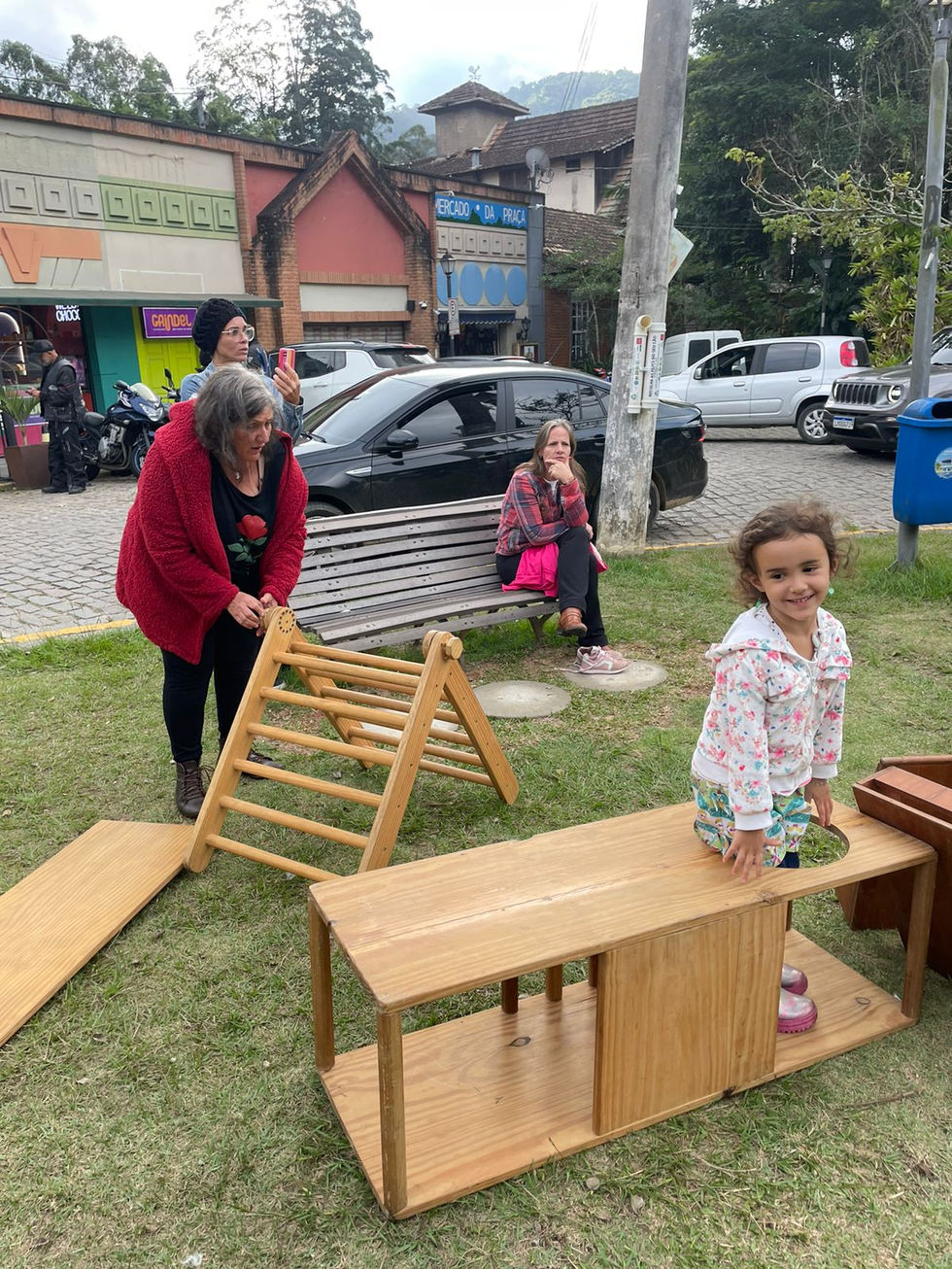 Menina sorrindo em equipamento de madeira na Festa das Crianças.