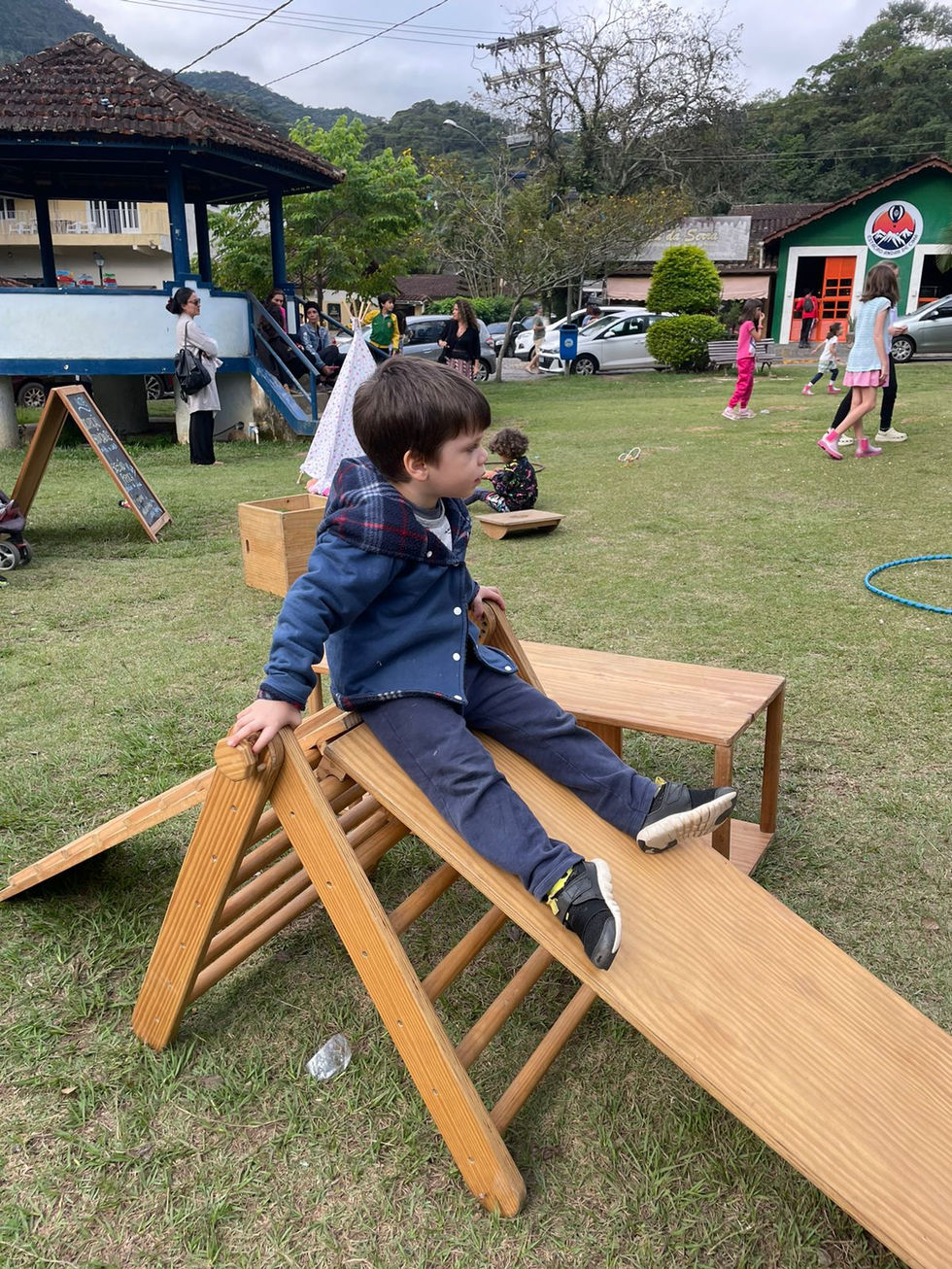 Menino brincando em estrutura de madeira na Festa das Crianças.