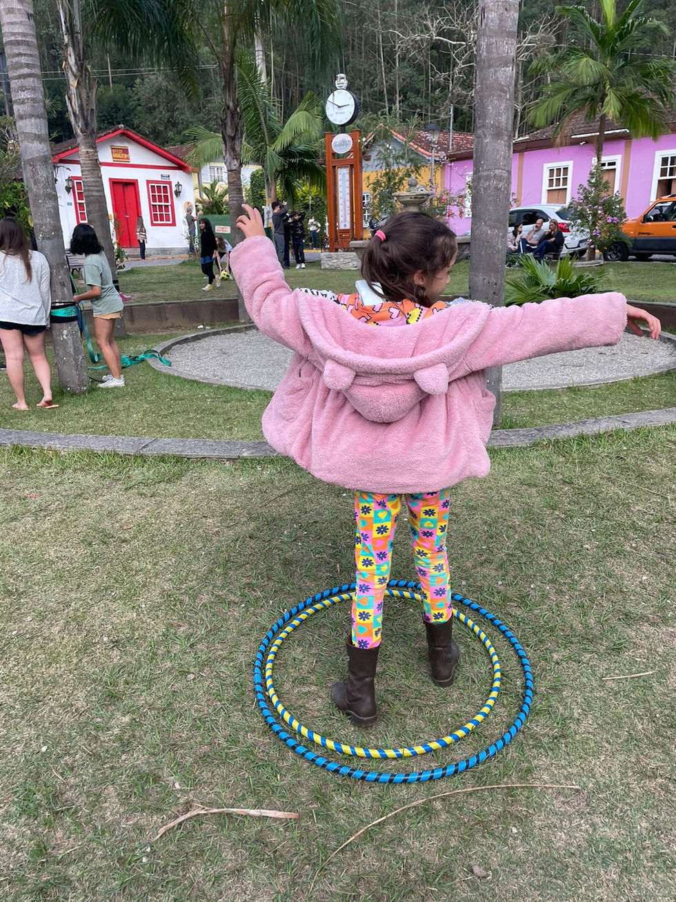 Menina brincando com bambolês na Festa das Crianças