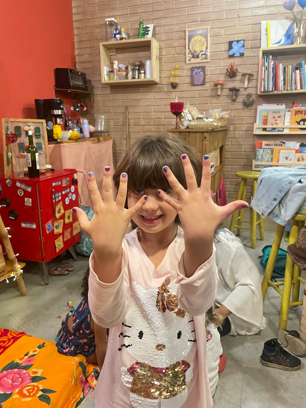 Menina sorrindo mostrando unhas pintadas