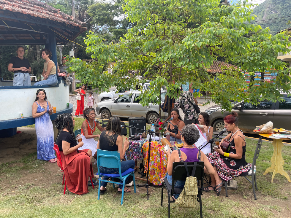 Mulheres reunidas num encontro animado ao ar livre.